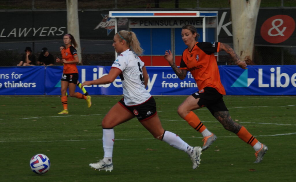 Larissa Crummer chasing Lauren Keir in an attempt to win the ball back in the Brisbane Roar versus Western Sydney game in December 2022