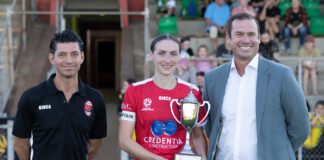 NPLW WA 2024 Round 7 Wrap Perth RedStar captain Sarah Carroll (c) with the Regional Festival of Football Trophy, alongside RedStar Carlos Vega Mena (l) and Football West CEO Jamie Harnwell (r)
