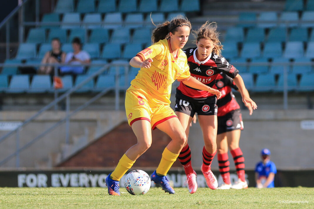 Adelaide's Emily Condon shields the ball from Wanderers midfielder Sarah Hunter during a 2020-21 A-League Women game between Western Sydney Wanderers and Adelaide United, played at Marconi Stadium. Photo credit: Kellie Lemon / KLZ Photography