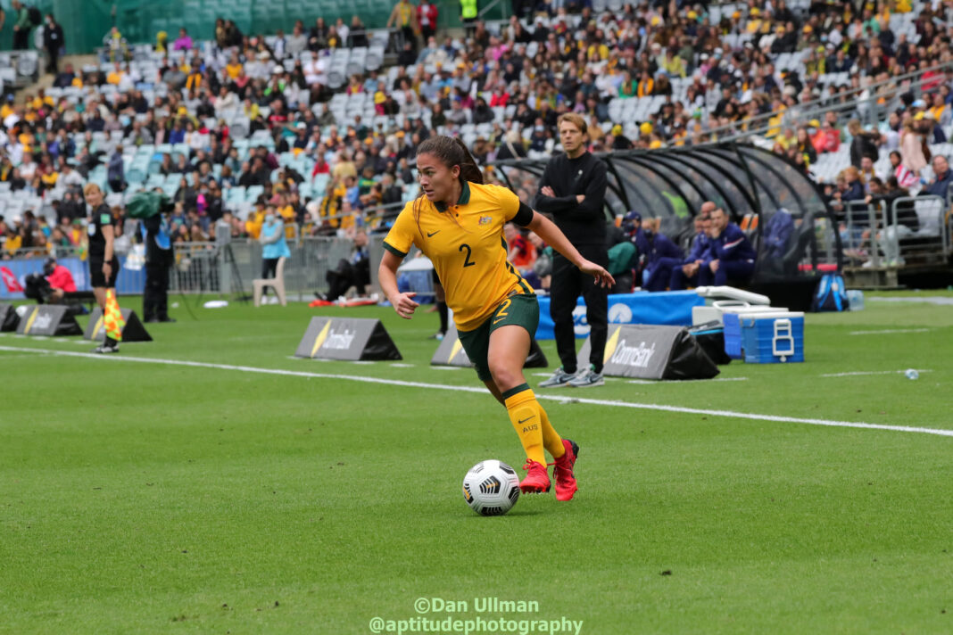 The Lost Aussie: Former Matildas defender Angie Beard runs with the ball during a game between the Matildas and USA, played at Stadium Australia on November 27, 2021. Photo credit: Dan Ullman (Instagram - @aptitudephotography )