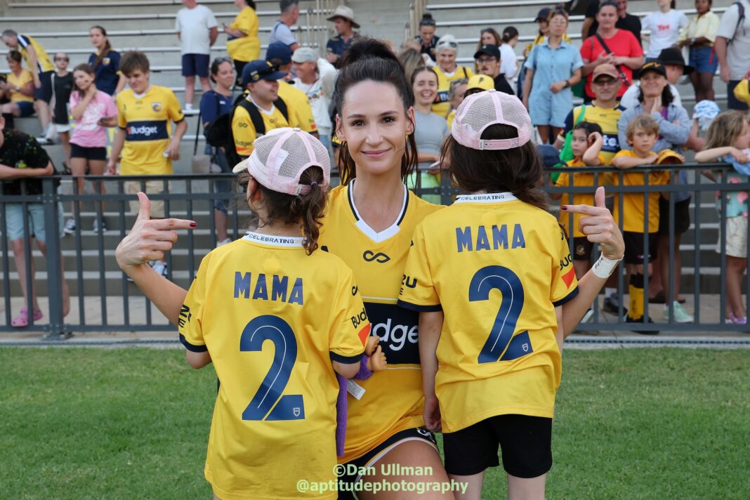 Central Coast Mariners defender Jessica Seaman poses with her children after making her (second) Mariners debut, in the A-League Women game against Wellington Phoenix at Woy Woy Oval, on January 26 2025. Photo credit: Dan Ullman (Instagram - @aptitudephotography )